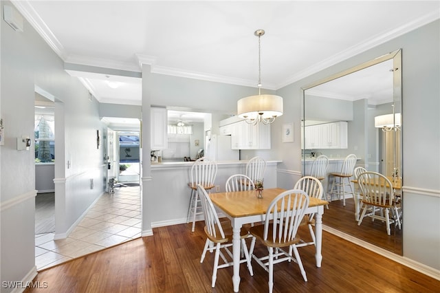 dining area featuring ornamental molding and light hardwood / wood-style flooring