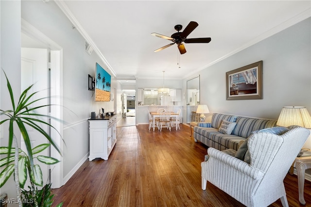 living room with ornamental molding, dark hardwood / wood-style floors, and ceiling fan