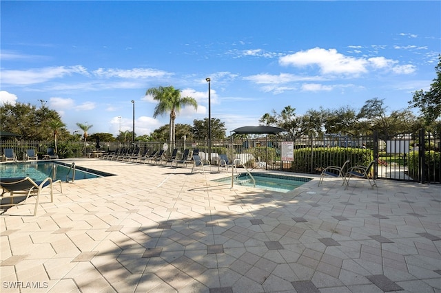 view of swimming pool with a hot tub and a patio