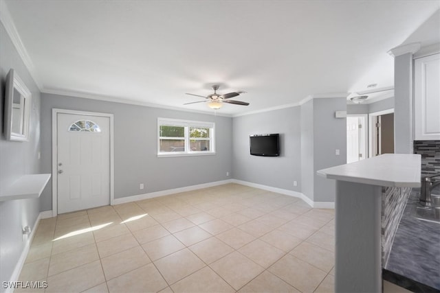 unfurnished living room featuring ceiling fan, light tile patterned floors, and ornamental molding