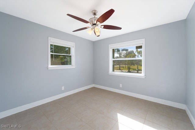 empty room with ceiling fan and light tile patterned floors