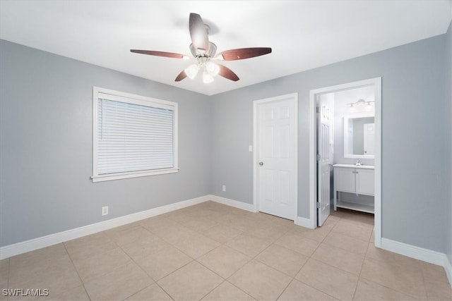 unfurnished bedroom with light tile patterned floors, ceiling fan, and connected bathroom