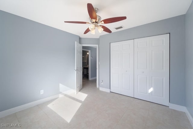 unfurnished bedroom with light tile patterned floors, ceiling fan, and a closet