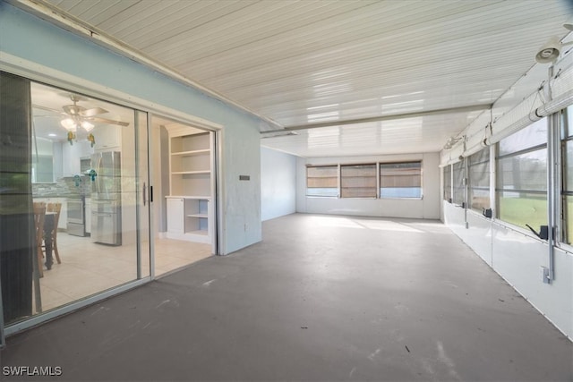 unfurnished sunroom featuring ceiling fan