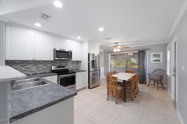 kitchen with appliances with stainless steel finishes, sink, crown molding, and white cabinets