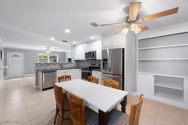 tiled dining space with sink and ceiling fan