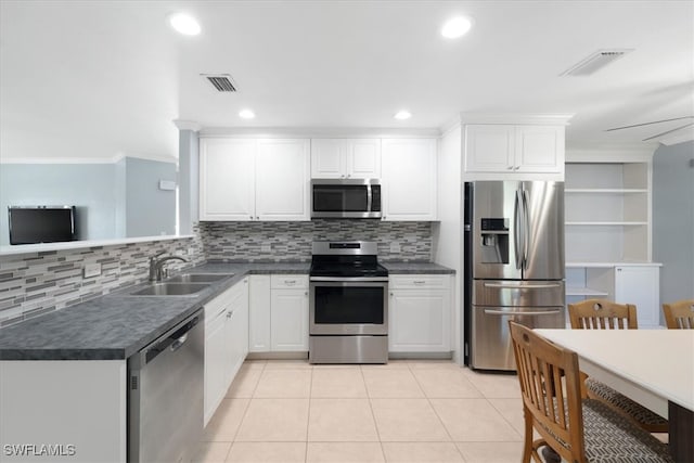 kitchen featuring tasteful backsplash, appliances with stainless steel finishes, light tile patterned floors, sink, and white cabinets