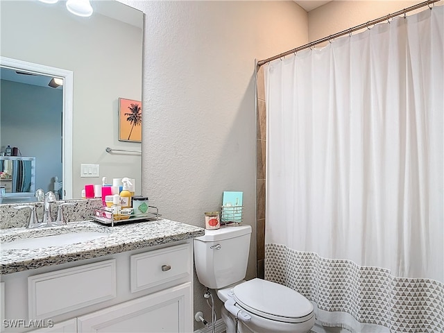 bathroom featuring a shower with shower curtain, vanity, and toilet