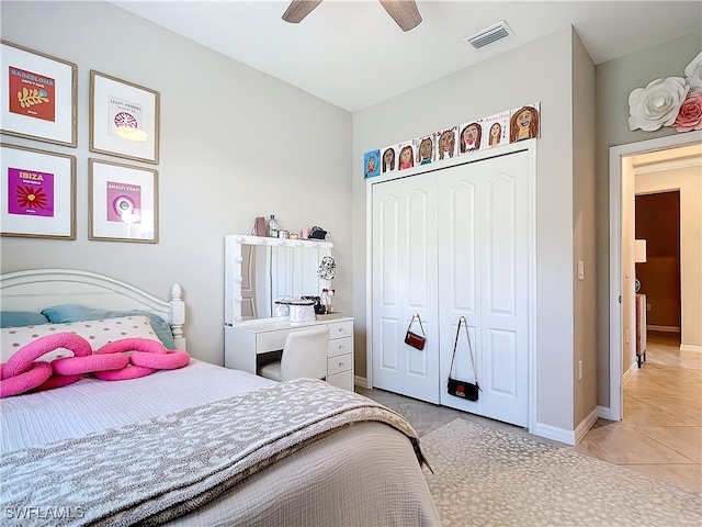 bedroom with light tile patterned floors, ceiling fan, and a closet