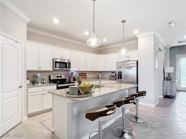 kitchen featuring white cabinetry, appliances with stainless steel finishes, a center island with sink, and crown molding