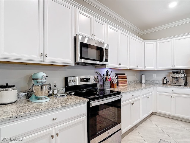 kitchen featuring white cabinets, light stone counters, ornamental molding, and stainless steel appliances