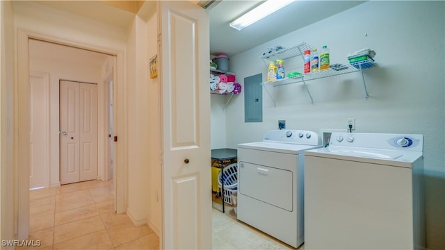 clothes washing area featuring light tile patterned flooring, electric panel, and washing machine and clothes dryer