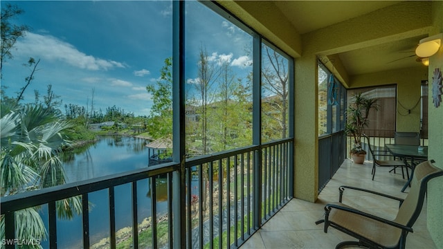 sunroom featuring a water view