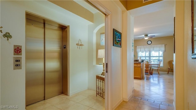 hallway featuring elevator and light tile patterned flooring