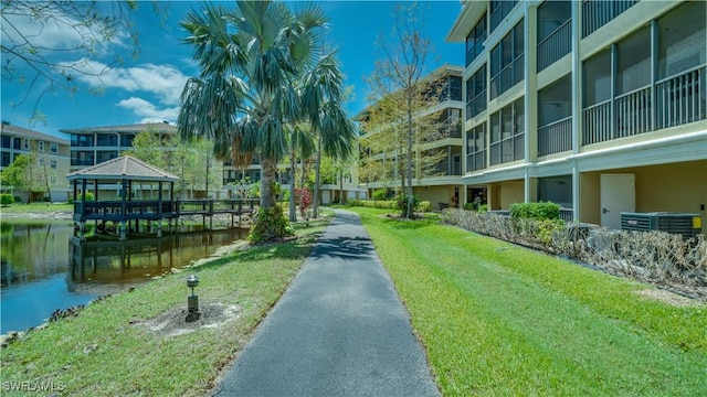 surrounding community with a gazebo, a water view, and a yard