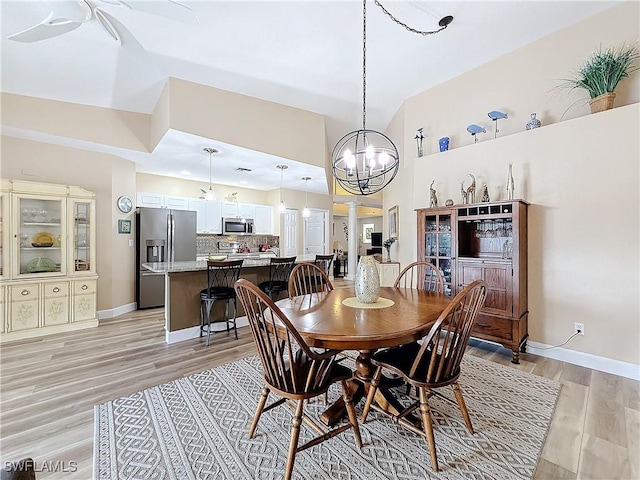 dining area with a notable chandelier and light hardwood / wood-style flooring