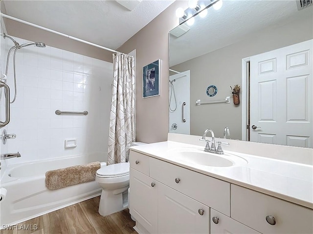 full bathroom featuring vanity, wood-type flooring, shower / bath combination with curtain, a textured ceiling, and toilet