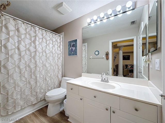 bathroom with vanity, hardwood / wood-style floors, toilet, and a textured ceiling