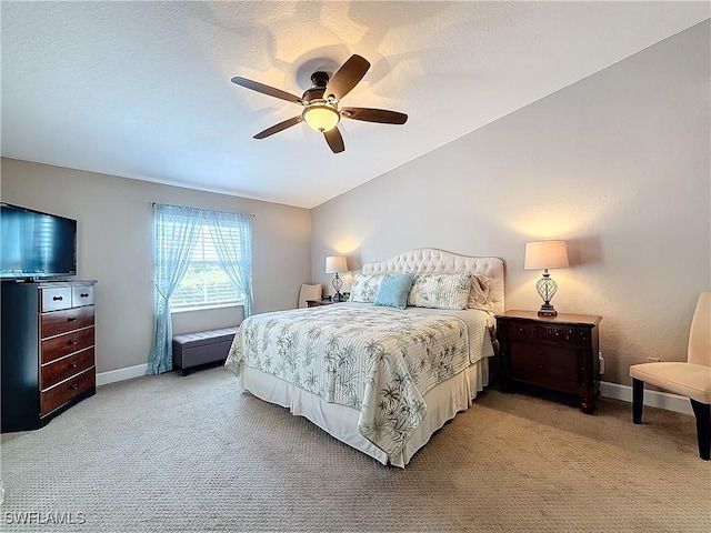 bedroom with a textured ceiling, vaulted ceiling, light colored carpet, and ceiling fan