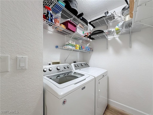 clothes washing area with separate washer and dryer and hardwood / wood-style floors