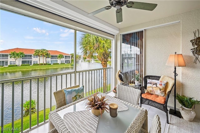 sunroom / solarium featuring a water view and ceiling fan