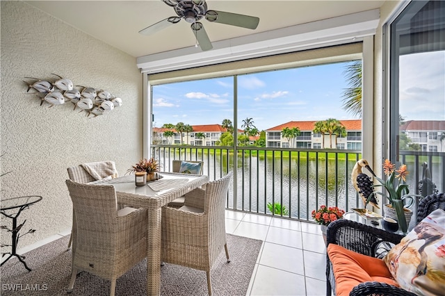 sunroom / solarium featuring a water view and ceiling fan