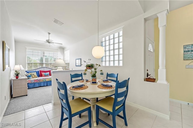 tiled dining space with ceiling fan and ornate columns