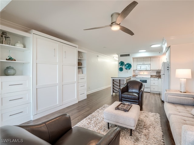 living room with dark wood-type flooring, ceiling fan, and crown molding