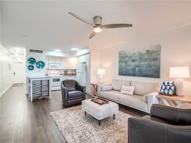 living room featuring ceiling fan, crown molding, sink, and dark hardwood / wood-style flooring