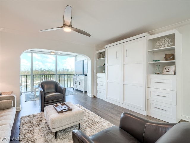 living room featuring crown molding, dark hardwood / wood-style floors, and ceiling fan