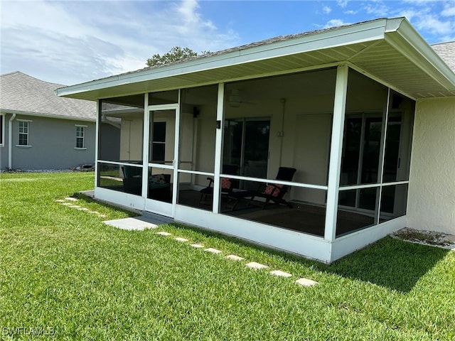 rear view of property with a lawn and a sunroom