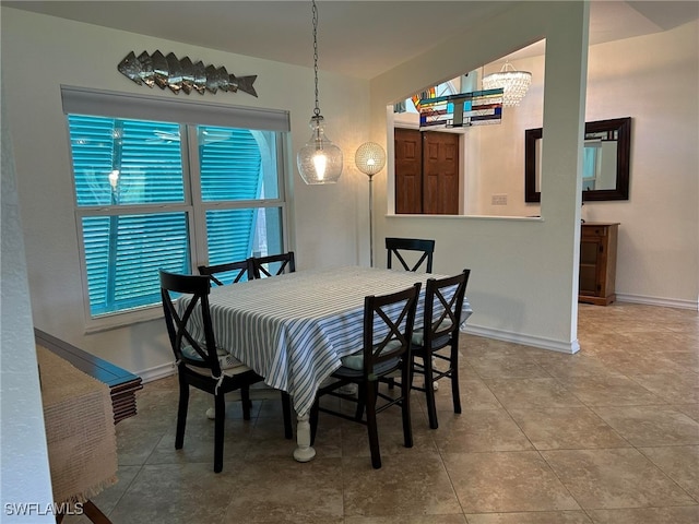tiled dining room featuring a chandelier