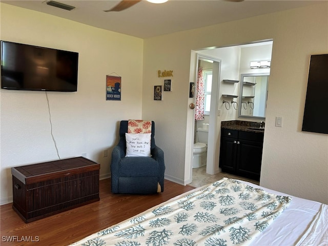 bedroom featuring sink, ceiling fan, hardwood / wood-style flooring, and ensuite bath