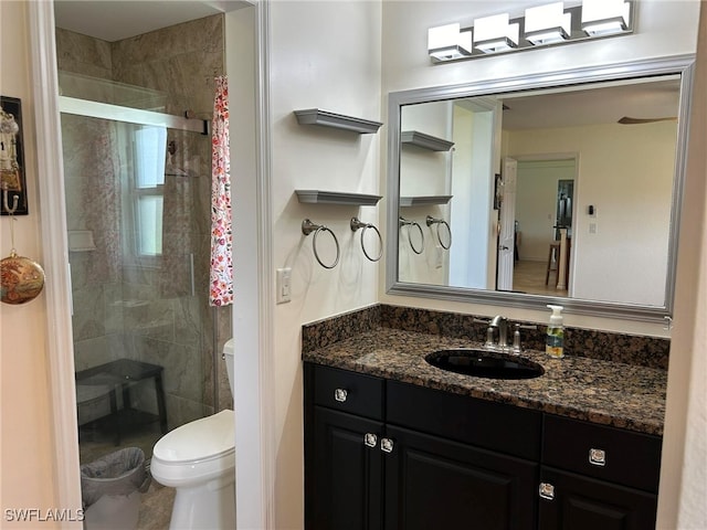 bathroom featuring vanity, toilet, and a shower with door