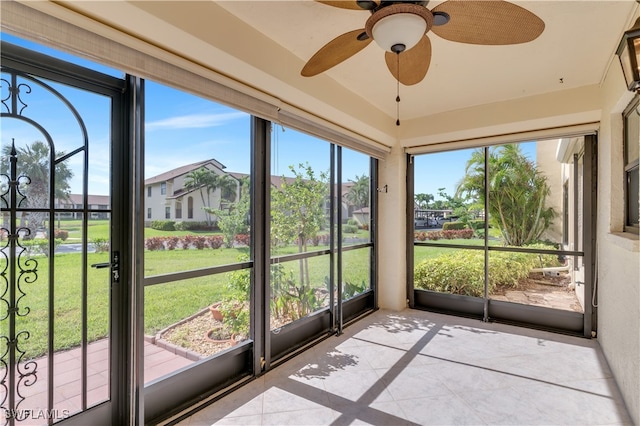 unfurnished sunroom featuring ceiling fan and plenty of natural light