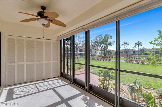 unfurnished sunroom featuring ceiling fan