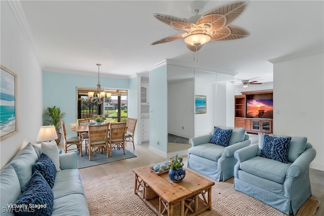 living room with ceiling fan with notable chandelier, light hardwood / wood-style flooring, and crown molding