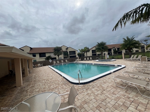 view of swimming pool with a patio and a hot tub