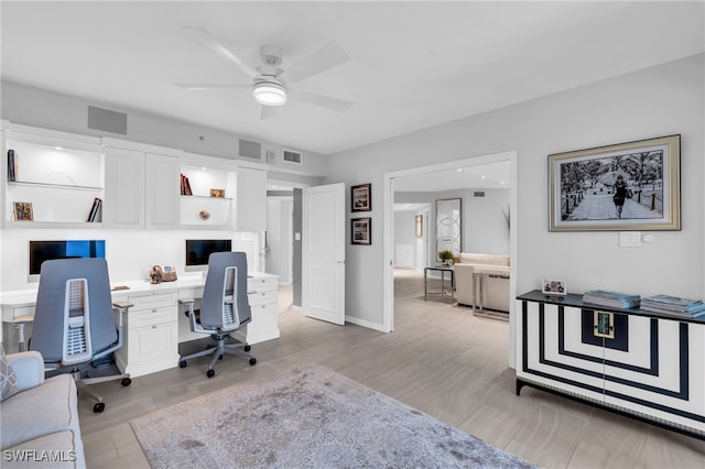 office area with built in desk, light hardwood / wood-style floors, and ceiling fan