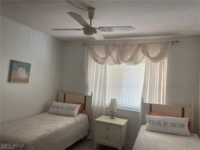 bedroom with ceiling fan and a textured ceiling