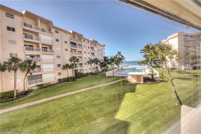 view of property's community with a lawn and a pool