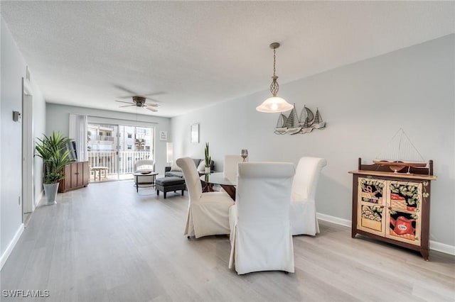 dining space featuring ceiling fan, light hardwood / wood-style floors, and a textured ceiling