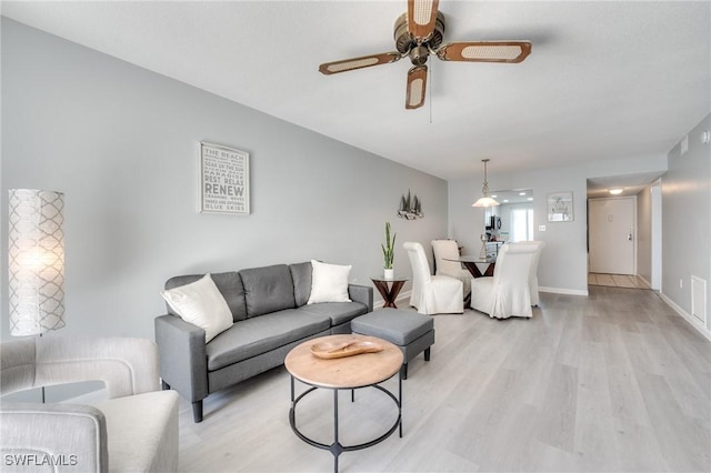 living room with ceiling fan and light hardwood / wood-style flooring