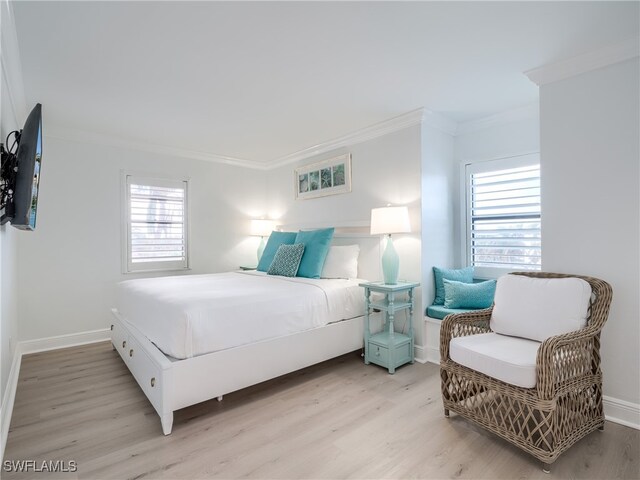 bedroom with light hardwood / wood-style floors and crown molding