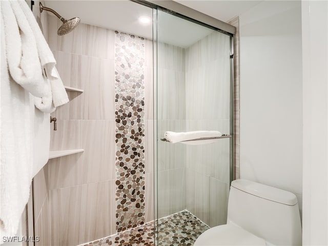 bathroom with toilet and a shower with shower door