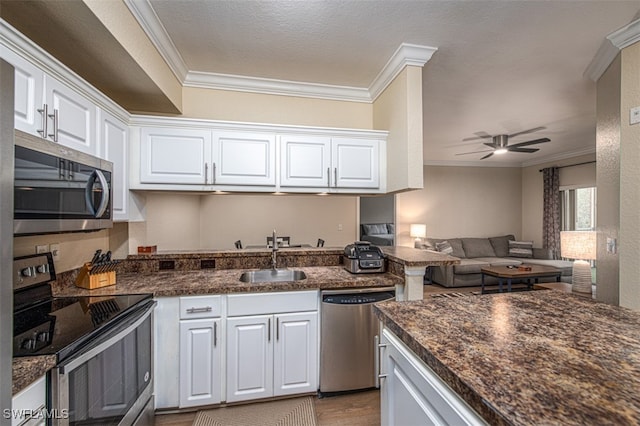 kitchen featuring white cabinetry, ornamental molding, and appliances with stainless steel finishes