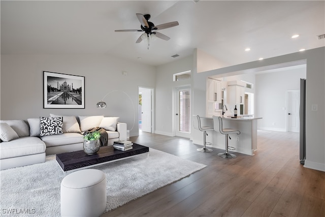 living room with wood-type flooring, ceiling fan, lofted ceiling, and sink