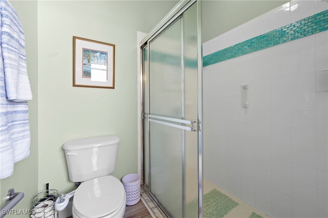 bathroom with an enclosed shower and toilet