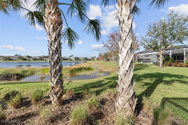 view of yard featuring a lanai and a water view