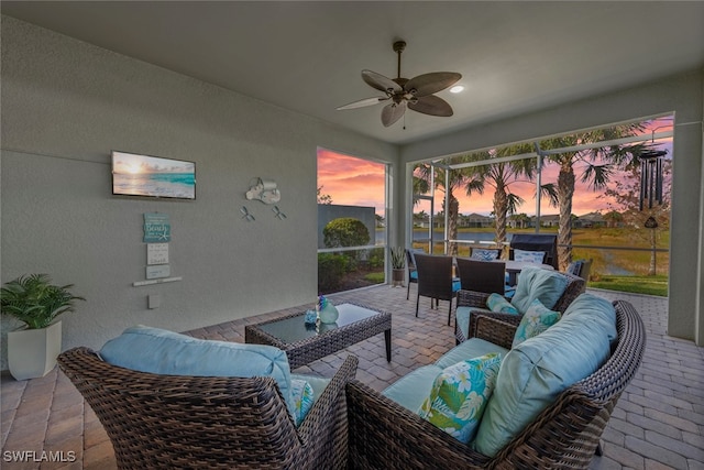 patio terrace at dusk with outdoor lounge area and ceiling fan